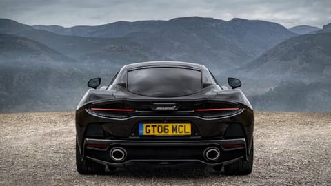 Rear view of a McLaren GT against mountains