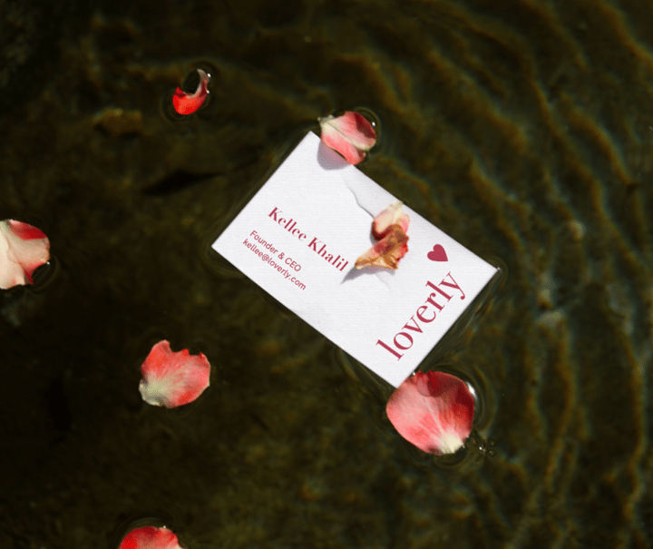 Loverly business card surrounded by rose petals on water