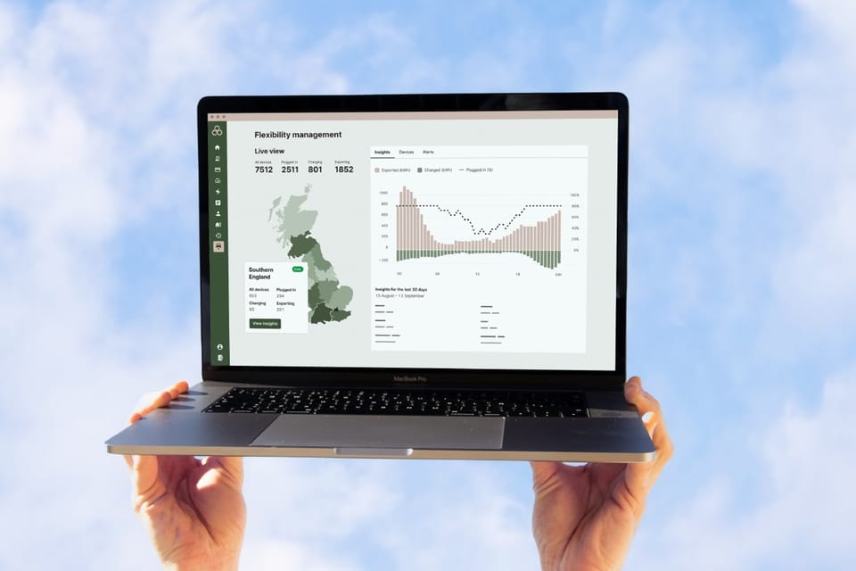 Kaluza platform dashboard on a laptop held against blue sky